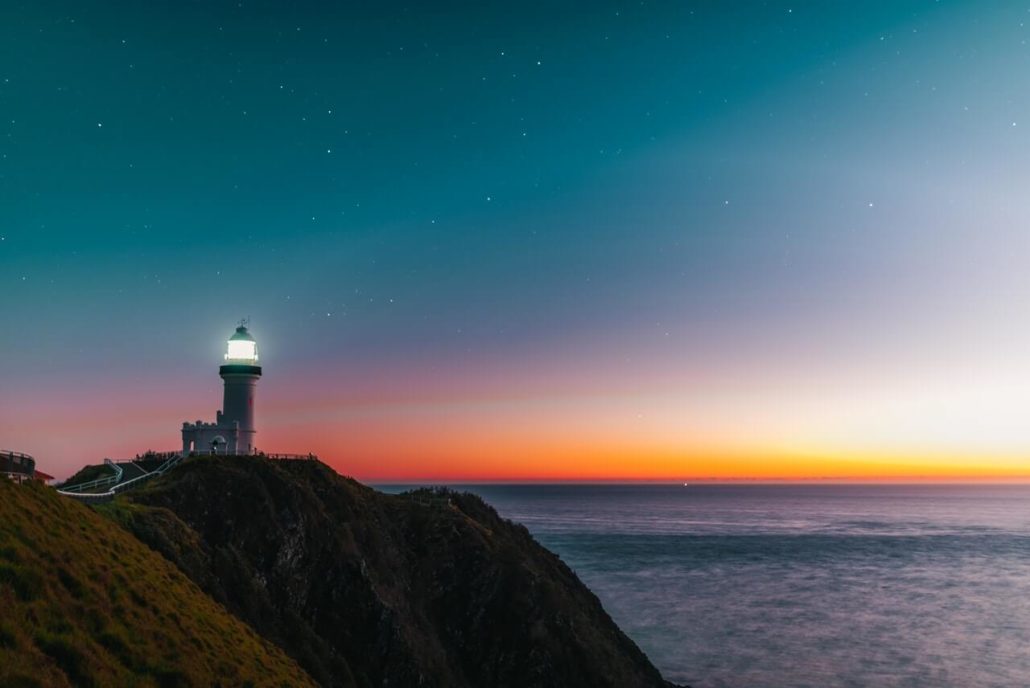 Lighthouse with sunset and galaxy