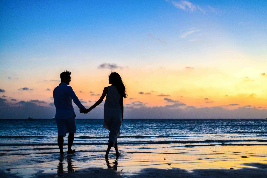 Two people standing on a beach