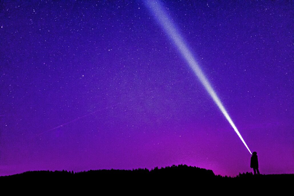 Person shining torch in sky