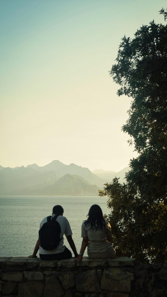Two people sat on a ledge
