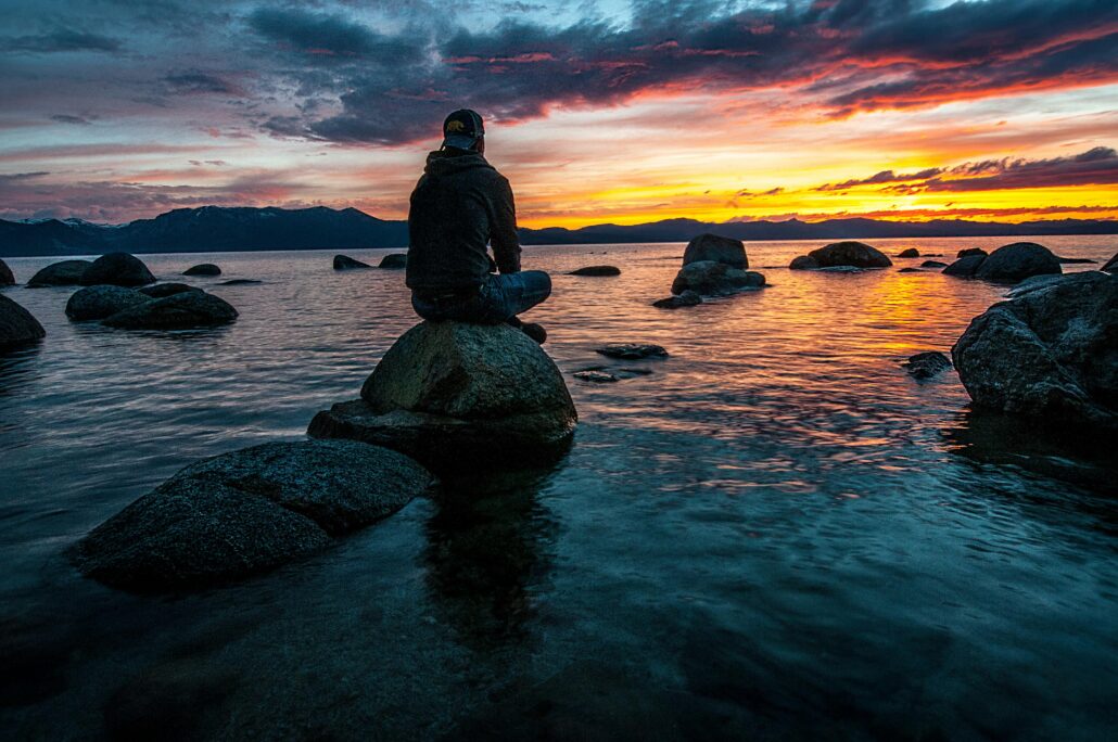 Man sitting on a rock at sunset